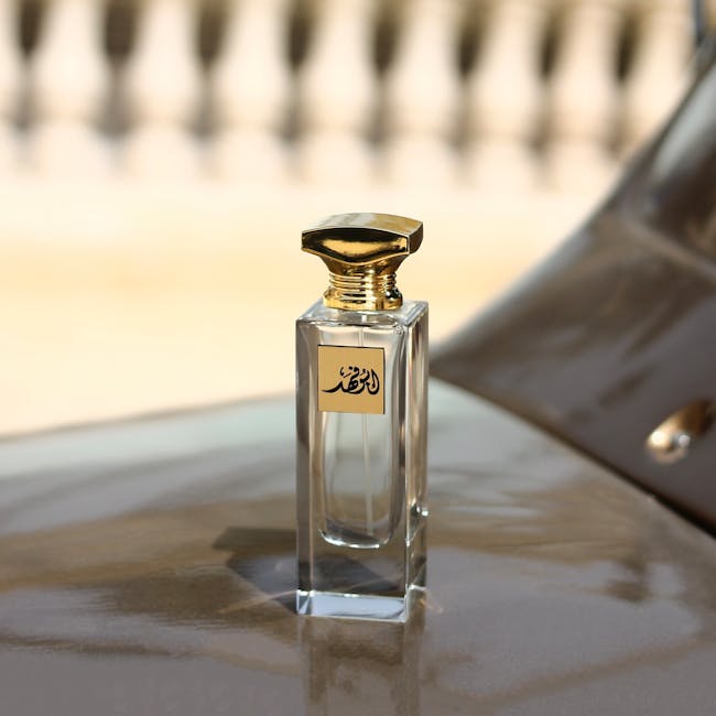 A luxurious perfume bottle with a gold cap and Arabic script against a blurred backdrop.